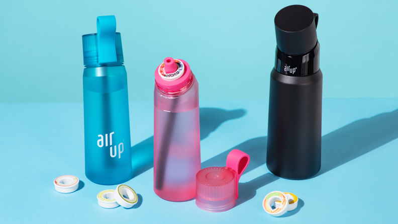 A blue, pink, and black stainless steel Air Up bottle on blue background
