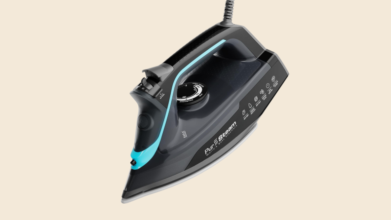 A PurSteam iron on a beige background