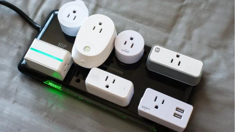 A series of smart plugs plugged into a power strip.