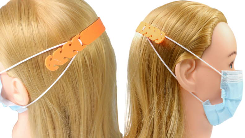 The back of a person's head with face mask straps clipped to a an orange plastic piece.