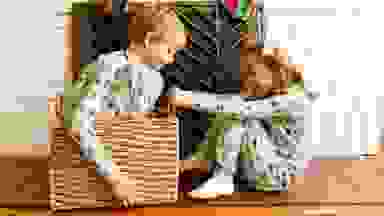 A boy in a big basket being pulled by his sister
