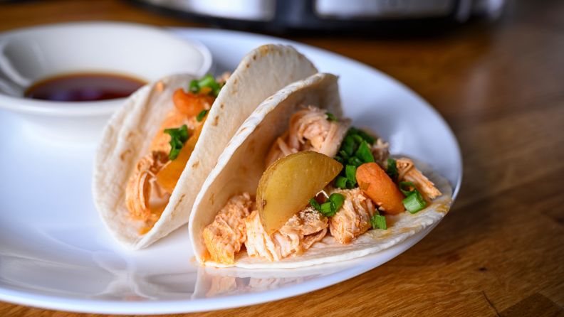 A plate of tacos filled with Korean chicken