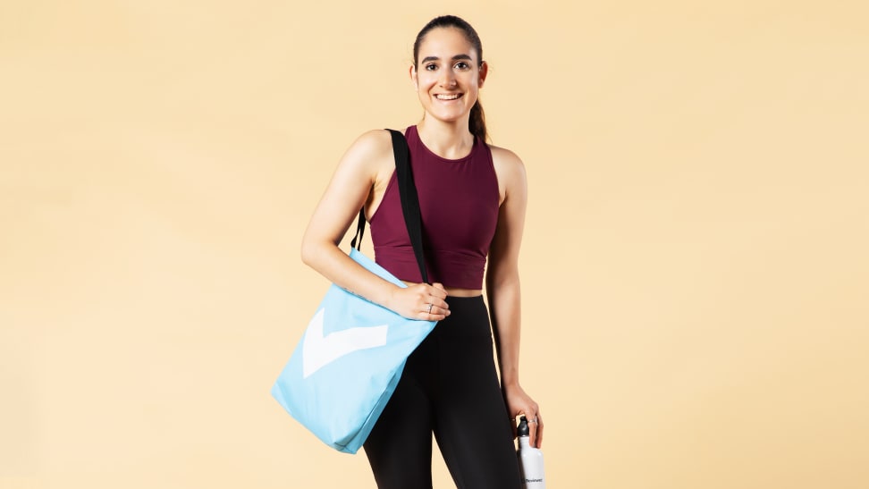 A model wearing Calia activewear with a Reviewed tote.