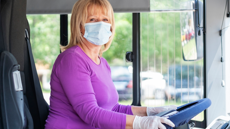 Woman bus driver wearing a mask.