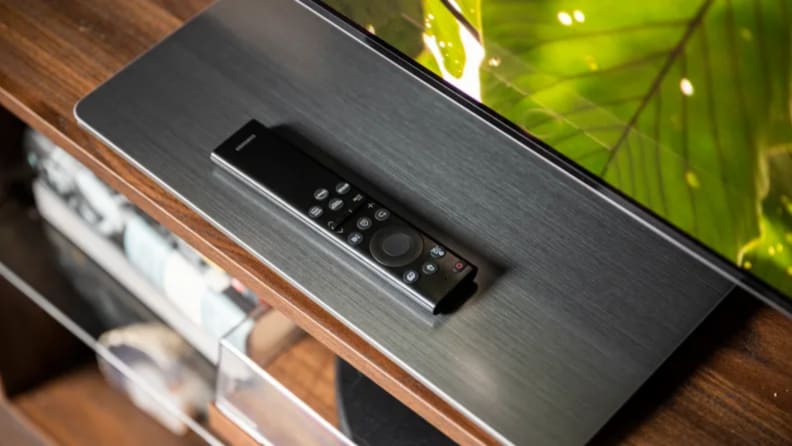 Un Gros Plan De La Télécommande Samsung Solar Cell Posée Sur La Surface Du Support Du S95B