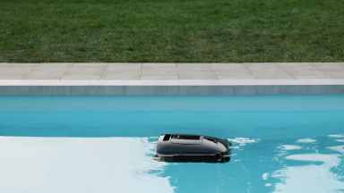 The black AquaSense Ultra 2 floats on the surface of the water in a pool.