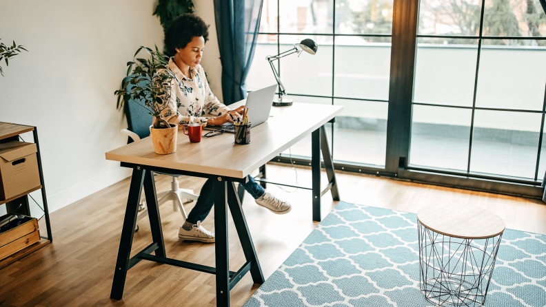 A person works inside a brightly lit home office.