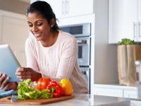 Woman looking at ipad with vegetables