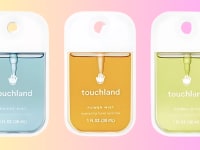 Three Touchland hand sanitizers on a colored background