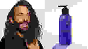 On the left: Jonathan Van Ness smiling at the camera. On the right: A purple bump bottle of shampoo.