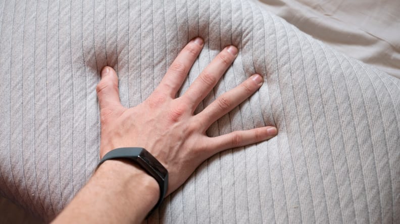 hand pressing down on memory foam pillow