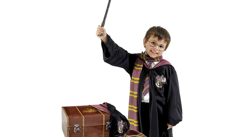 A boy dressed up as Harry Potter holding a wand.