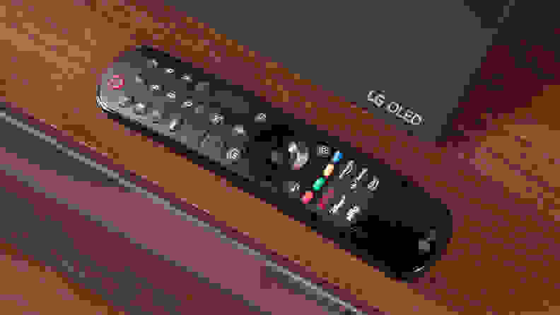 The remote of the LG C3 OLED TV on a TV stand.