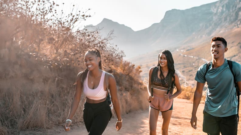 Three friends hiking up a hill.