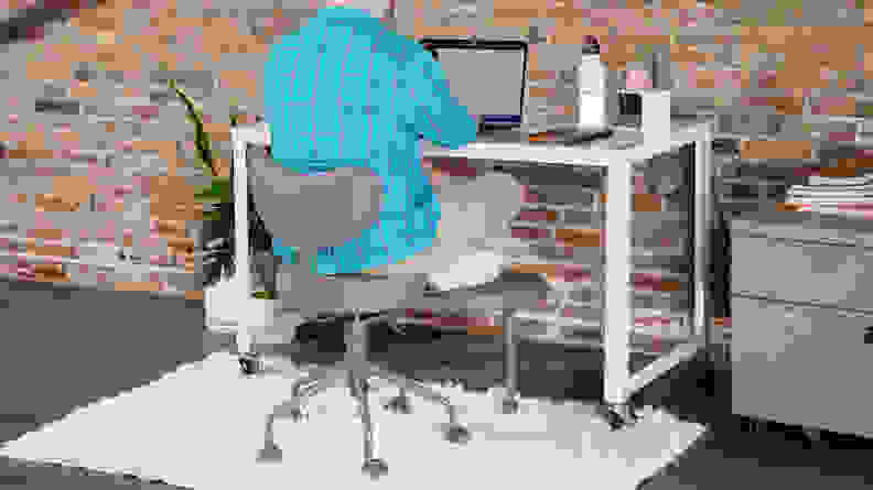 Person sitting cross-legged in the Pipersong Meditation Chair at desk while working on laptop.