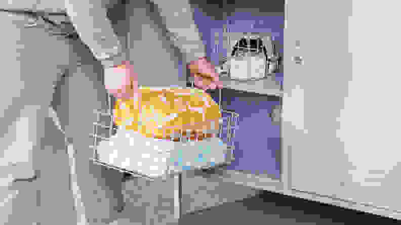 A person placing a storage basket into the Mustard Made locker.
