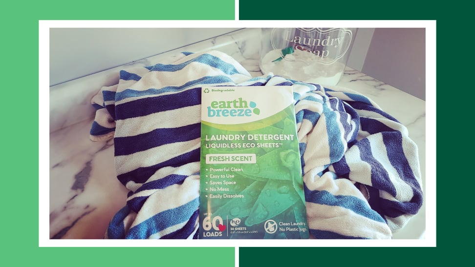 Box of Earth Breeze eco-friendly laundry sheets on top of towel next to jar of powdered laundry