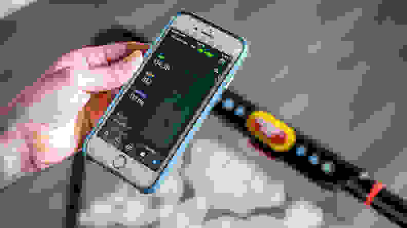 A hand holding a phone showing the Treadly app on the screen.