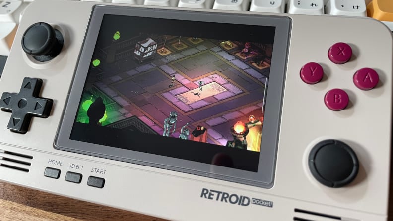 A close-up shot of the Retroid Pocket 2+ with a still from Hades on the screen.