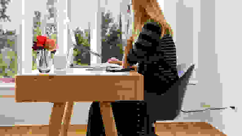 坐在书桌前用电脑工作的女人