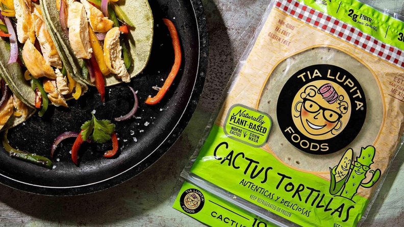 A plate of chicken fajitas sizzling next to a pack of tortillas from Tia Lupita Foods.