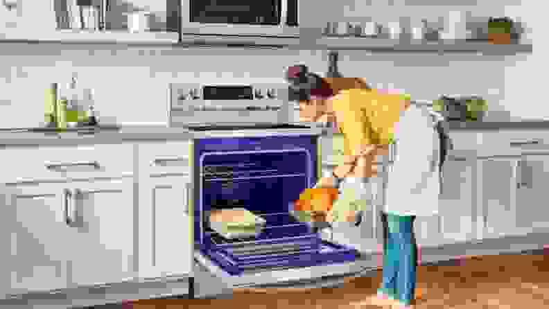 Person removing a cooked turkey from the LG electric range in a kitchen
