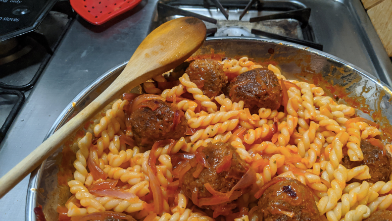 Pasta and meatballs cooking in pan