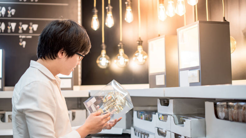 Person choosing pack of light bulbs in a home improvement store