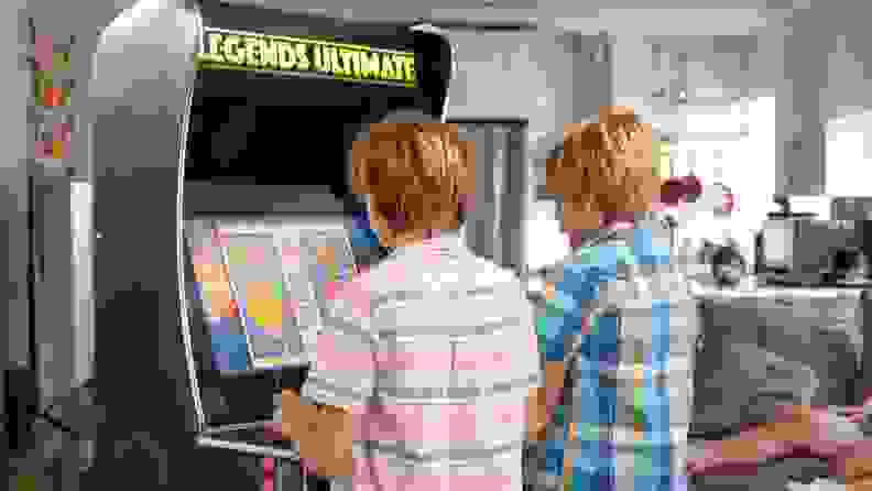 Two young boys playing the Legends Ultimate arcade cabinet.