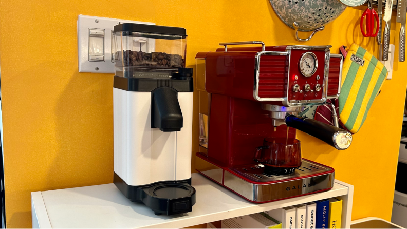 A white and black espresso machine next to a red Galanze espresso machine.