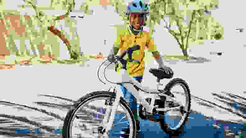 A boy stands proudly over a new bike, beaming with his smile.