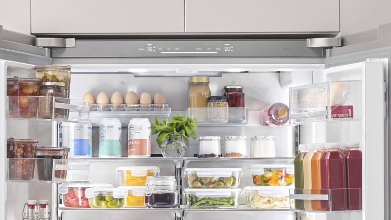 An open refrigerator showing leftover food and ingredients in storage containers.