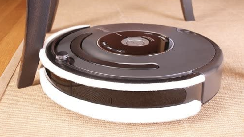 A robot vacuum with a white bumper around the edge.