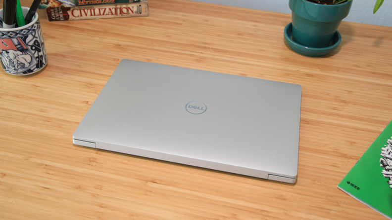 A closed sliver laptop on top of a desk.