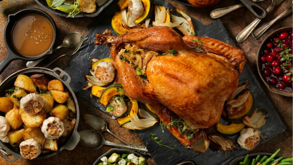 A top-down photo of a Thanksgiving feast with a beautifully golden turkey front and center.