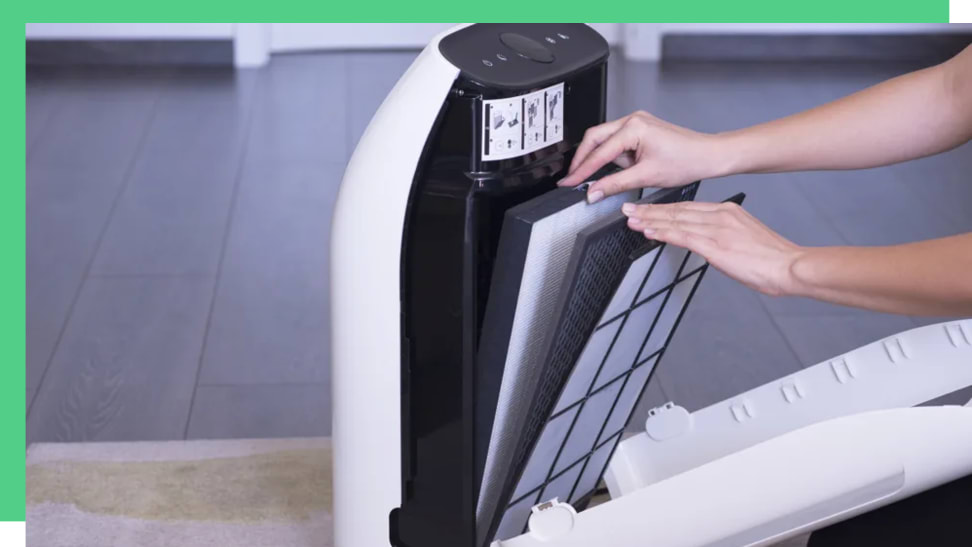 Person using hands to change air filter on small white air purifier.