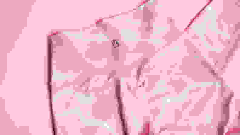 A close-up of the back of a pair of pink leggings on a pink background.