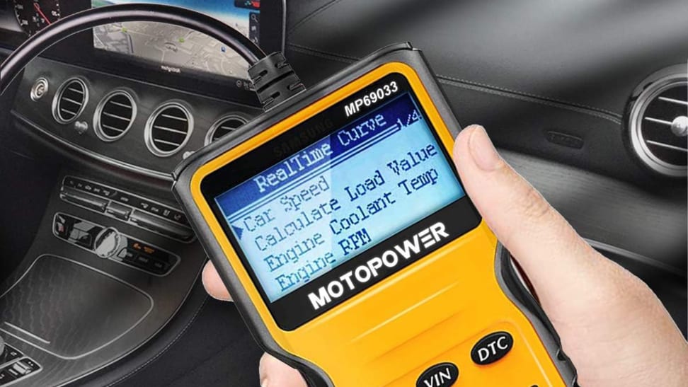Someone holding a Motopower Car Scanner inside a car.