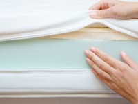 hands show the layers of a mattress