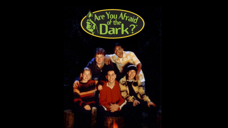 An image of the title card for Are You Afraid of the Dark? featuring teens around a campfire.