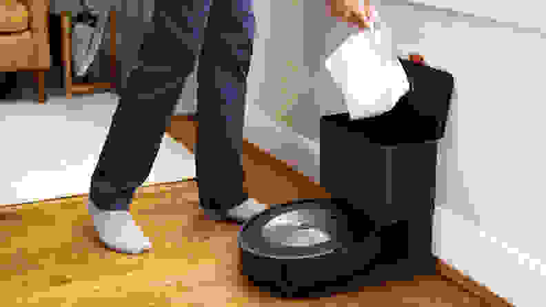 A self-sealing bag being removed from the iRobot Roomba J7+ charging base.