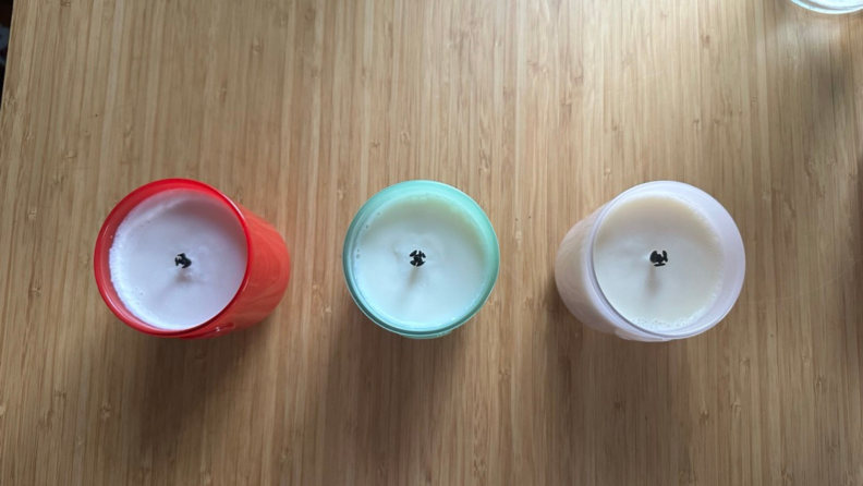 An aerial view of the three Glossier candles lined up on a table.