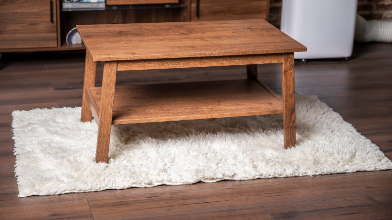 On left, person pouring mug of coffee onto white shag rug. On right, white shag rug with brown stain.