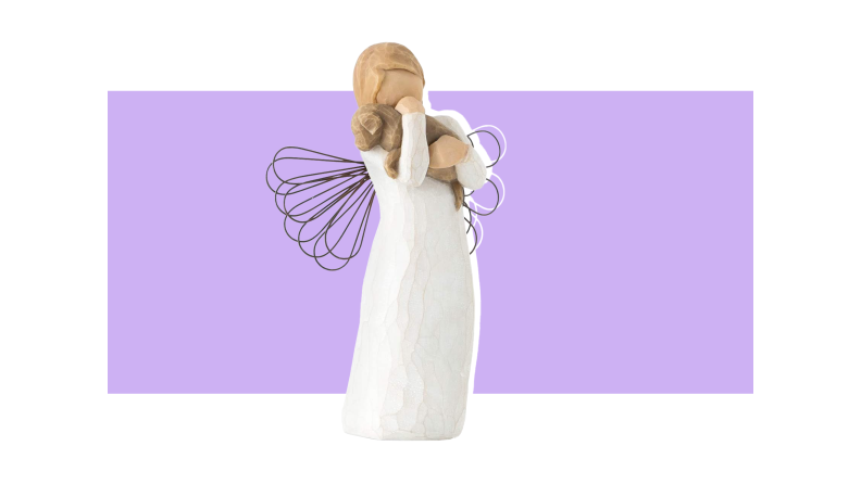A wooden Angel figurine holding a brown wooden dog against a purple background.