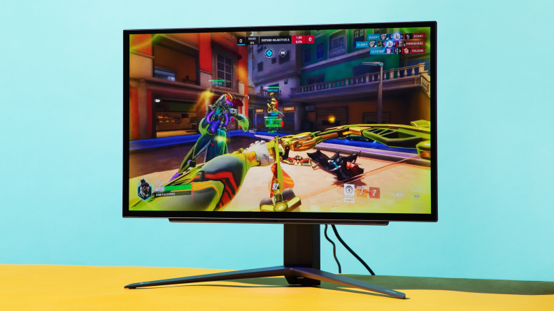 a gaming monitor on a stand with a colorful first person shooter on screen