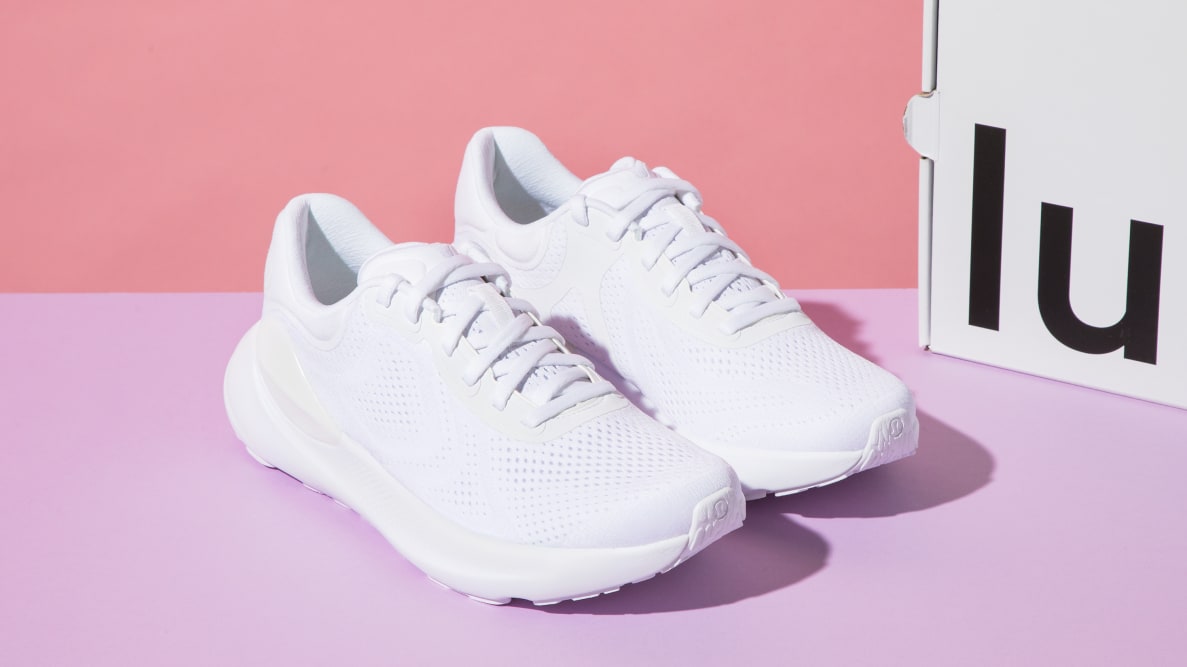 A white pair of lululemon Beyondfeel sneakers next to a cardboard box.
