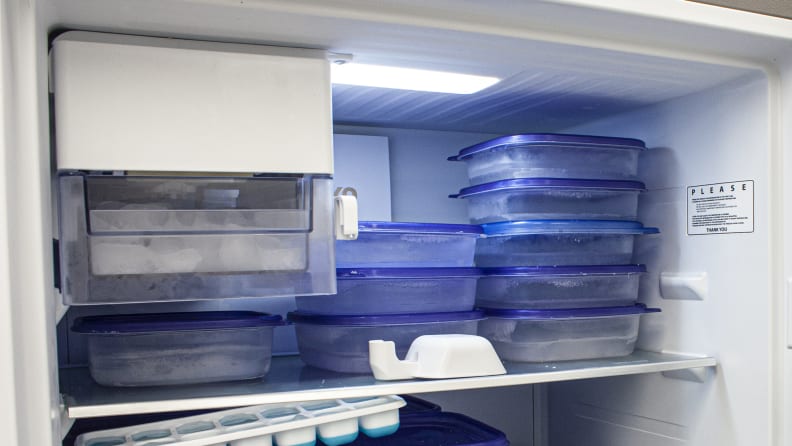 A close-up of the freezer, showcasing the ice maker in the top left. The freezer compartment is filled with plastic containers of water ballast, from our freezer temperature tests.