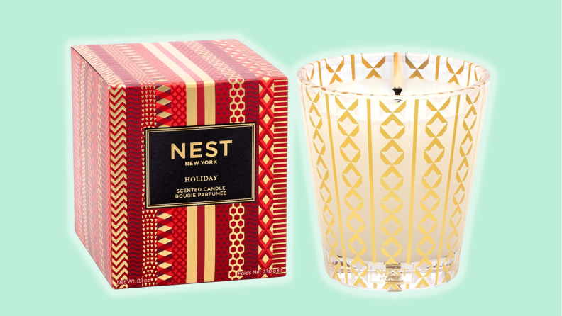 The Nest candle and its box against a blue background.