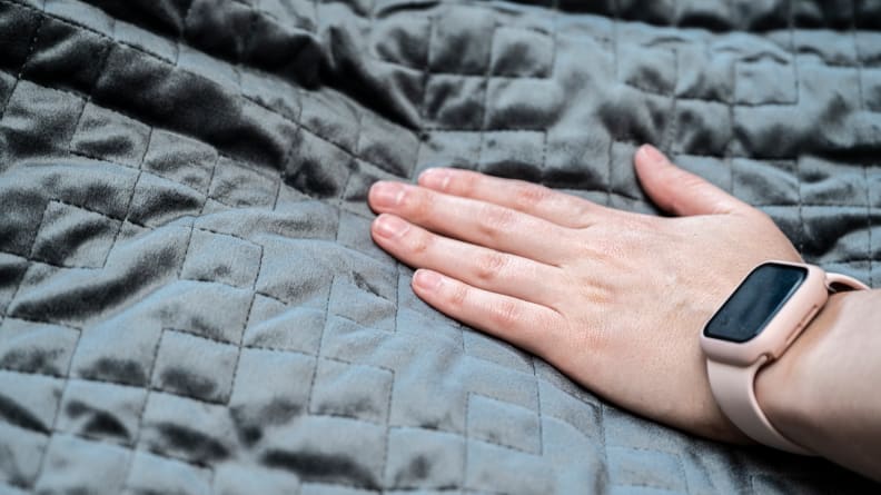 a woman touches the Gravity Blanket's plush cover