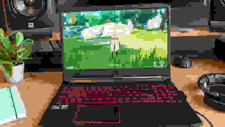 The laptop is on a desk, displaying a game
